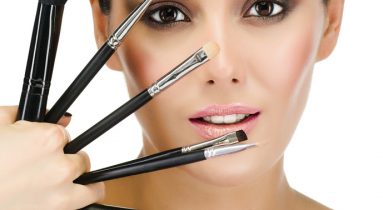 portrait of attractive  caucasian  woman brunette isolated on white studio shot looking at camera face skin makeup closeup brushes