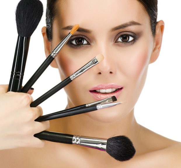 portrait of attractive  caucasian  woman brunette isolated on white studio shot looking at camera face skin makeup closeup brushes